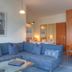 Seetelhotel Ostseeresidenz Bansin living area with blue sectional sofa, glass coffee table and dining nook