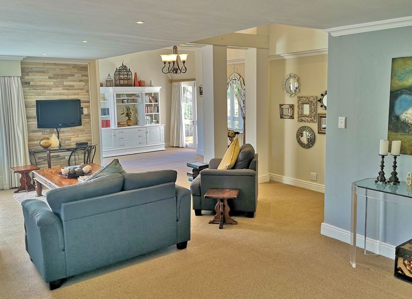 Val d'Or Estate in Franschhoek lounge with sofas, TV, glass display cabinet and artwork