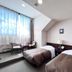 Hotel Sun Abashiri guest room with two twin beds and a window seating area in Abashiri