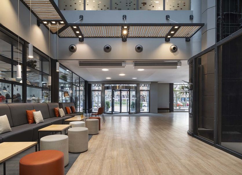 Dorma Juan De Austria in Valladolid lobby with modern seating, glass walls, and a high ceiling