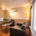 Arass Hotel & Business Flats Antwerp living area with sofa, armchair, TV and coffee table