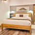 La Villa Boutique Hotel, Accra: wooden bed in a bright guest room with ensuite bathroom doorway