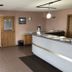 Denison Inn & Suites lobby with front desk, seating area, and tiled floor in Denison