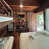 Boutique Village Hotel in Krabi wooden guest room with bunk beds, king bed, and balcony view