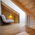 Mijama Suites Split loft room with wooden ceiling, lounge chair and stair railing