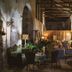 Glamping Canonici di San Marco in Mirano: rustic candlelit dining hall with tables and chairs