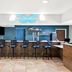 The Hotel Saratoga in Saratoga Springs bar with stools, TV, and blue butterfly wall art