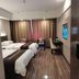 Shell House Hotel in Baoding guest room with two beds, desk, wall-mounted TV and curtains
