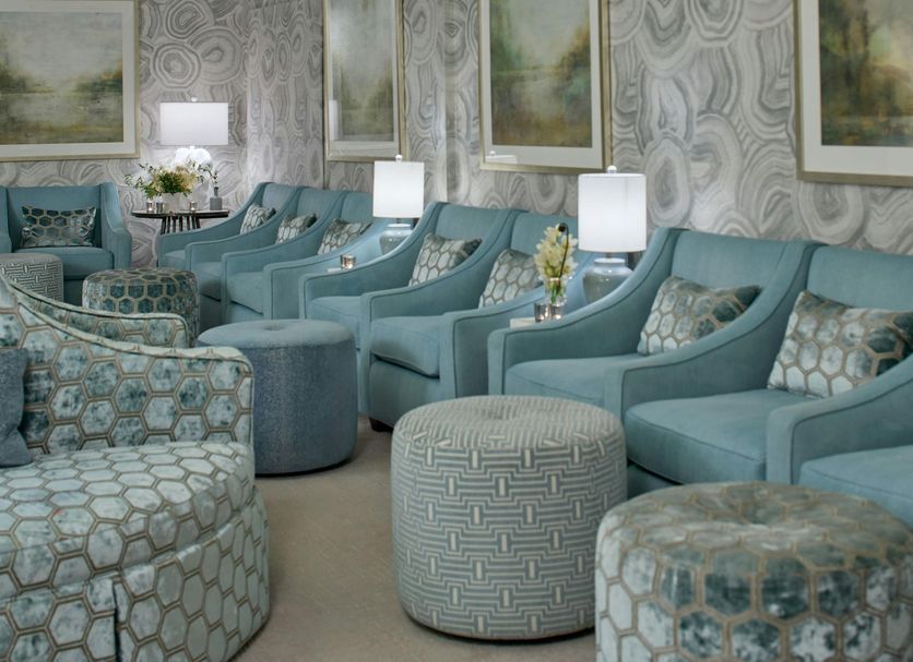 The Del Monte Lodge Renaissance Rochester Hotel & Spa in Pittsford lounge with teal seating and patterned ottomans