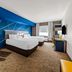 Comfort Inn & Suites Donna guest room with two beds, blue accent wall, desk, and armchair