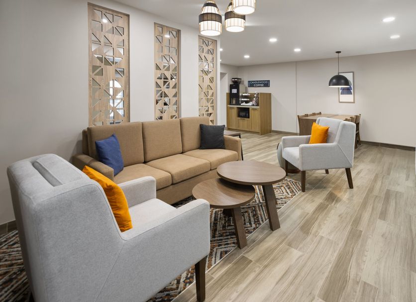 Candlewood Suites Williamsport lobby seating area with sofas, chairs, coffee tables and wood-look flooring