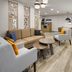 Candlewood Suites Williamsport lobby seating area with sofas, chairs, coffee tables and wood-look flooring