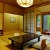 Shima Grand Hotel in Nakanojo: Japanese-style room with low table and chairs beside large garden-view windows.
