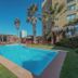 Hotel Canto del Mar in La Serena with outdoor pool, palm trees and sun loungers