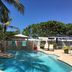 The Beach Guesthouse in La Torre: tropical outdoor pool with lounge chairs and palm trees