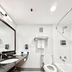Lincoln Hotel Monterey Park Los Angeles bathroom with tub, toilet, vanity and wall-mounted toiletries