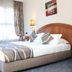 Cherry Maryski Hotel Alexandria guest room with double bed, bedside lamp, and window curtains