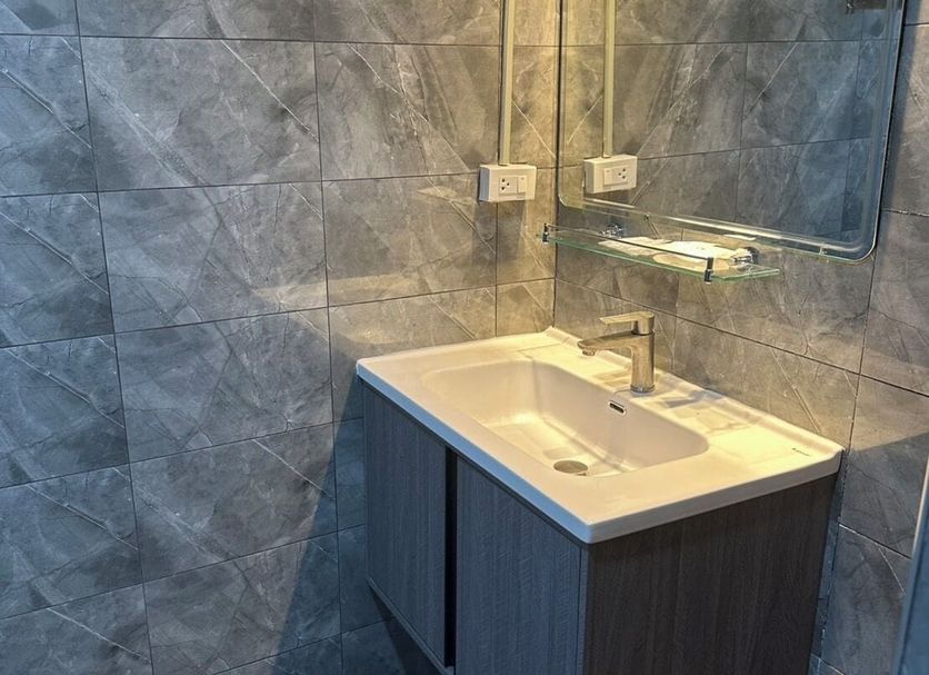 Kata Leaf Resort in Karon bathroom with sink vanity, mirror, and tiled shower area