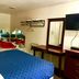 Passport Inn and Suites - Middletown guest room with blue bedspread, desk, wall-mounted TV and mirror