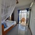 Aqua Resort, Diani Beach room with canopy bed, mosquito net, tiled floor and balcony seating