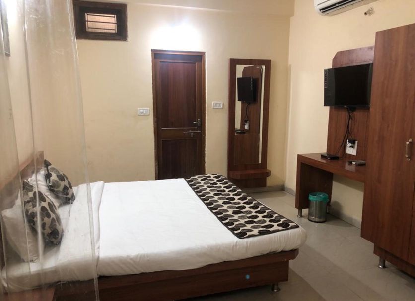 Goroomgo Mourya Inn Madhya Pradesh room in Harda with bed, wardrobe, TV and mirror