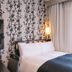 Apa Hotel Nagoya Marunouchi Ekimae guest room with bed, floral wallpaper and bright window in Nagoya