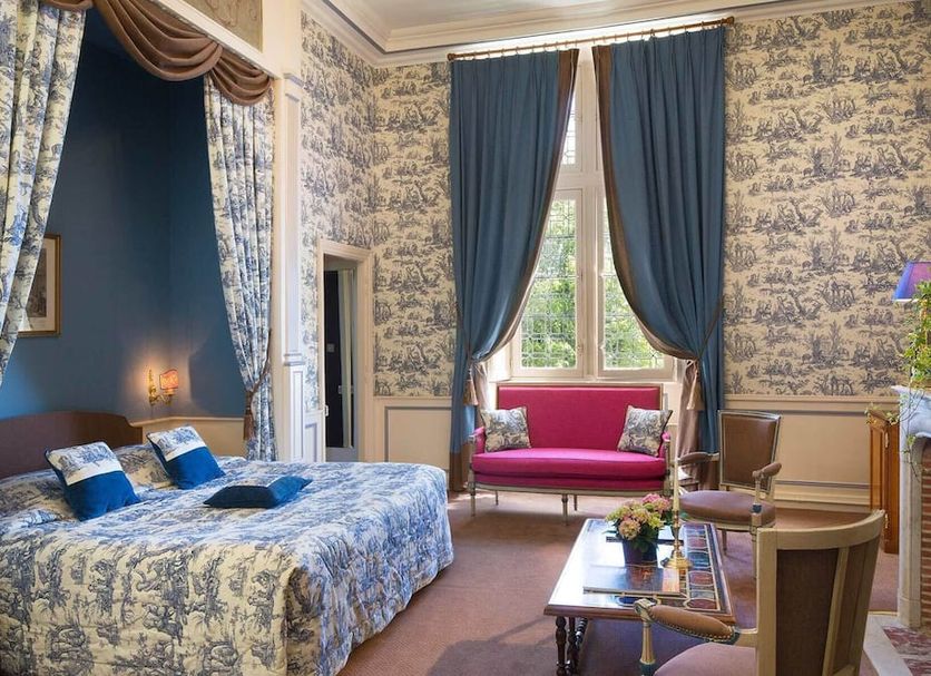 Château de Noizay room in Noizay with canopy bed, tall drapes, pink loveseat and fireplace