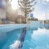 Belvedere Village in Agia Pelagia with an outdoor pool, sun loungers, and sea-view sky