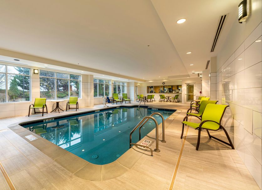 Hilton Garden Inn Winchester indoor pool with lounge chairs and large windows