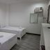 Coron Sanho Pension House in Coron room with two single beds, wall mirror, air conditioner, and tiled floor