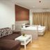 Baan Klang Hua Hin room with sofa, TV, bed, desk, and curtains in Hua Hin