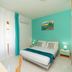 Tra i Monti in Tramonti guest room with double bed, teal accent wall and turquoise curtains