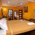 La Villa Creole Pondicherry guest room with four-poster bed, TV, and balcony doors
