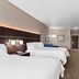 Holiday Inn Express & Suites Ada guest room with two beds, TV, desk and seating area in Ada