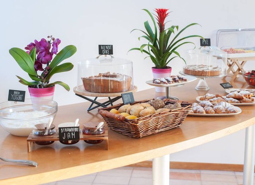 Ha Hotel Bracciano breakfast buffet with pastries, fruit, yogurt, and potted orchids