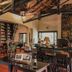 Posada Puerto Bemberg in Puerto Libertad lounge with bookshelves, red chairs and high wooden beams