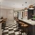 Holmes Hotel London bar with island counter, pendant lights and black-and-white checkered floor in London
