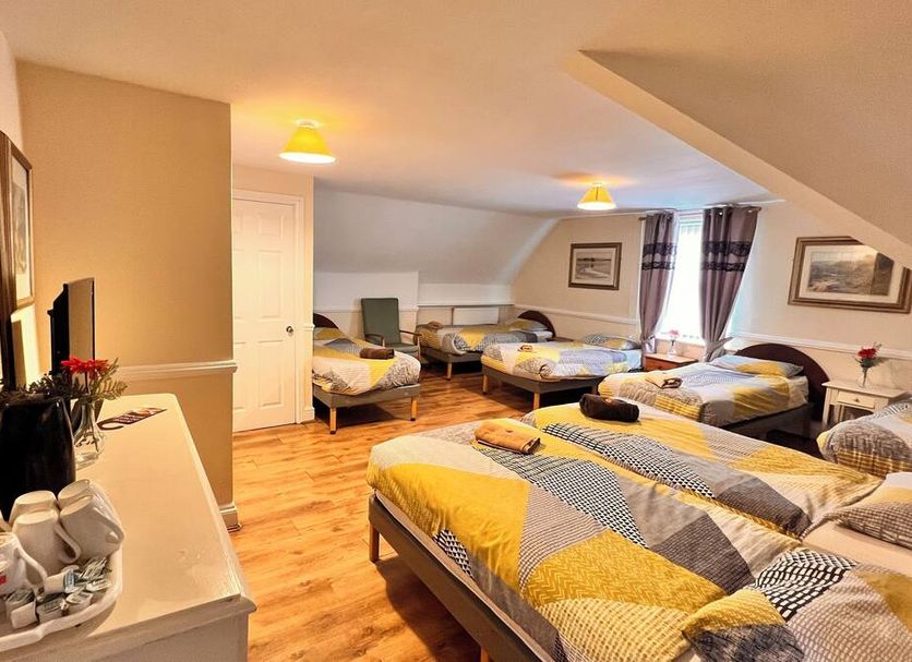 Castle Lodge Guest House in Liverpool: attic room with four twin beds and sloped ceiling