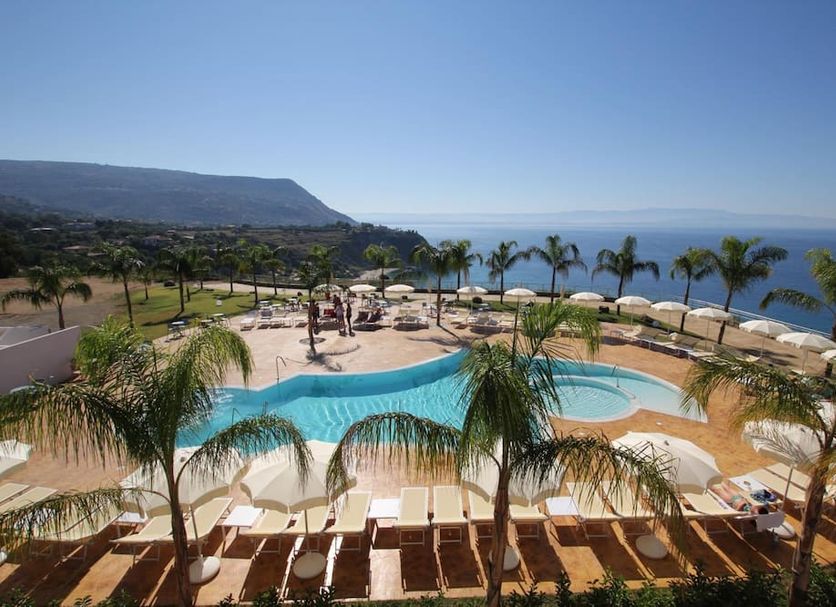 Blue Bay Resort Capo Vaticano pool terrace with palm trees and sea view