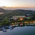 Expo Garden Resort Hotel in Jinan with lakeside view, tree-covered hills and marina at sunset