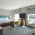 Hampton Inn Santa Clarita-Valencia guest room with king bed, desk, sofa and city view