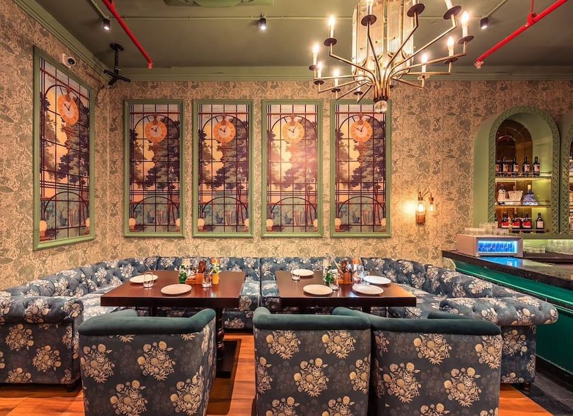 Connaught Royale Delhi in New Delhi: floral booth seating and stained-glass panels in a stylish dining room