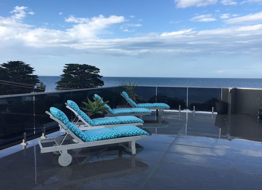 Starhaven Retreat in Indented Head: ocean-view terrace with blue lounge chairs and glass railing