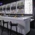 Aloft Kansas City Country Club Plaza bar with white counter, black stools and backlit bottle display in Kansas City