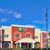 Holiday Inn Express & Suites Bradenton West By IHG exterior with flags and palm trees in Bradenton