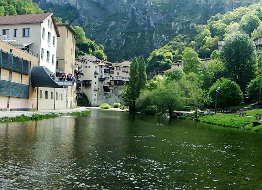 Hôtel du Musée de l'Eau in Pont-en-Royans beside a river with village buildings and lush mountain cliffs