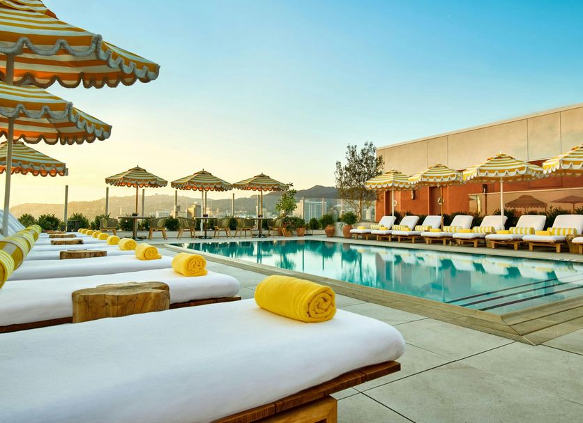 The Hollywood Grande, Autograph Collection in Los Angeles with poolside loungers and striped umbrellas