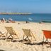 Hotel Amerique in Palavas-les-Flots with beach chairs on a sandy shoreline beside calm blue sea