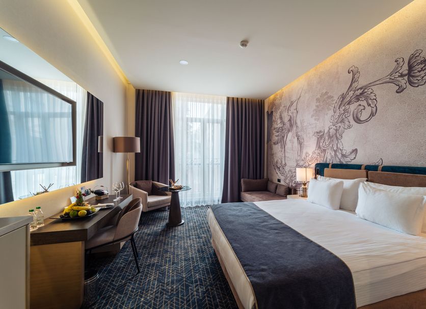 Ic Hotels Airport Antalya guest room with king bed, desk, seating area and large window