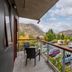 Shotover Lodge in Queenstown balcony with chairs overlooking mountains, trees, and parking area